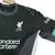 Camisa reserva do Liverpool 2024/2025 peito, verde escuro que parece preto, com o escudo Liver Bird em branco e o swoosh da Nike em branco. Detalhes em cinza e branco, 2 II Away masculino preto. Camisa Liverpool 2024, camisa reserva Liverpool 2024, verde 