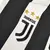 Logo da Adidas em dourado na camisa titular Juventus 2017/2018 Home I Masculino Retrô em branca e preta. Logo posicionado no lado direito do peito, combinando com o novo escudo da Juventus no lado esquerdo. Usada por Dybala, Cuadrado e Higuaín.