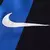 Logo da Nike na camisa Inter de Milão 2024/2025 Home I titular masculina nas cores azul e preto. Localizado no lado direito do peito em branco, complementa o design com modernidade. Parte do uniforme icônico usado por Lautaro Martínez.