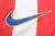 Logo da Nike na camisa titular Atlético de Madrid 2004-2005, modelo Home, com patrocínio Homem-Aranha 2, logotipo de Tobey Maguire e Fernando Torres, masculino, cores vermelha e branca. O logo da Nike é posicionado no lado direito do peito, em uma camisa 