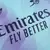 Close do peito da terceira camisa Arsenal 2024/2025 versão jogador, com logos do patrocinador e Adidas trevo em azul petróleo, fundo em azul celeste, lilás e roxo, usada por Saka e Odegaard em competições como a Champions League.