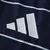 Logo da Adidas em prata na terceira camisa Aston Villa 2024/2025 III Third Masculino azul marinho. O icônico logo prateado está localizado no lado direito do peito, alinhado com as três listras prateadas nos ombros, que reforçam a identidade da marca.