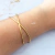 Bracelete Lyra cruzado em aço inoxidável dourado - comprar online