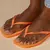Sandálias Havaianas Square Sparkle em tom laranja, com detalhes brilhantes, usadas por uma pessoa. glitter,quadradinha,quadrada