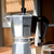 Cafetera de aluminio marca Hudson, con diseño tradicional y mango negro, sobre una mesa de madera.