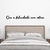 Quadro em MDF com a frase "Que a felicidade vire rotina" acima de uma cama com cabeceira de madeira.
