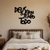 Quadro decorativo com a frase "Deus é bom o tempo todo" em MDF, pendurado na parede acima de uma cama em um quarto aconchegante.