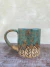 Caneca de cerâmica artesanal com design de folhas, capacidade de 250ml.
