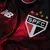 Detalhe da camisa 3 do São Paulo FC, com o logo da New Balance e o escudo do time em destaque, em tons de vermelho.