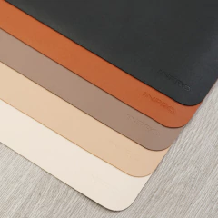 Conjunto de cinco desk pads ECO em cores variadas dispostos em superfície de madeira clara