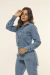 Imagem da modelo vestindo a Camisa Jeans Feminina Alongada Gio vista de frente, com destaque para os bolsos frontais e o comprimento alongado da peça.