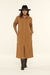 Modelo vestindo o Vestido Chemise Midi Amélia Marrom, vista frontal, destacando o caimento elegante, os botões frontais e a cintura marcada.

