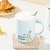 TAZA DE CERAMICA CON TAPA + CUCHARITA DISEÑO LAZY CAT - 450 ML