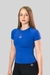 Camiseta de compressão feminina na cor azul, modelo ajustado, usada por uma jovem com cabelos longos e lisos.