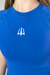 Camiseta de compressão feminina na cor azul, com logotipo branco na parte frontal.
