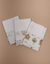 Trio de fraldinhas com estampas dos três porquinhos em fundo claro.