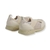 Zapatillas Rex de color beige para niños y niñas, diseñadas para primeros pasos, con una parte superior de malla y tiras elásticas.

