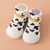 Zapatillas ergonómicas blancas con diseño de vaca, ideales para primeros pasos de niños y niñas.