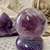 Amethyst Sphere weighing 670g, a stunning piece for spiritual spaces. Its purple hues exude tranquility and elegance, making it perfect for meditation or as a decorative item. Known for its spiritual and healing properties, it's an ideal addition for thos
