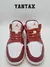 Zapatillas Jordan 1 Low Dune Red en color rojo y blanco, vistas desde el frente, con detalles de perforaciones en la puntera.