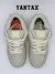 Un par de Nike SB Dunk Low Mummy en color gris claro, vista desde arriba, con detalles de costura visible y cordones blancos.