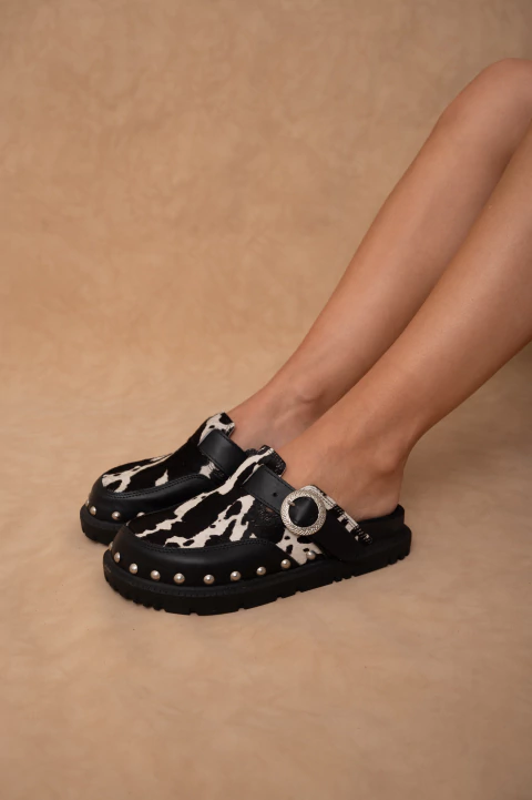 suecos Paloma con estampado animal print, hebilla metálica y tachas. Cómodas, trendy y únicas para darle personalidad a tu look.