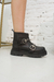 bota de cuero color negro con cierre delantero y tiras ajustables.