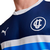 Camiseta azul de la Universidad Católica para aficionados, con detalles en blanco y logo de Puma.