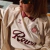 A person wearing the Köln Retrô 2025 jersey in cream and burgundy, featuring the Hummel logo and a collar design.