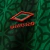 Close-up of the Umbro logo on a green jersey, featuring an intricate pattern.