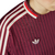 Cerca de la camiseta roja de fútbol Adidas Bayern Munchen con rayas y el logo de la marca en el pecho.