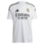 Frente de la Camiseta Real Madrid Home 24/25 Kylian Mbappé Camisa 9: Diseño blanco clásico con detalles dorados, celebrando la llegada de Kylian Mbappé al Real Madrid. El icónico número 9 destaca en el uniforme de los merengues.