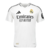 Camiseta Real Madrid 2024/25: Vista frontal. Diseño blanco con patrón de pata de gallo y las iniciales RM. Detalles en negro en las rayas de las mangas y el cuello en V, representando la elegancia y tradición del club.