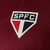 Close-up of the São Paulo FC logo on a burgundy jersey from New Balance.