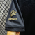 Close-up of the sleeve of a black jersey featuring gold embroidery with the name "Pelé" and the text "1.000 GOLS."