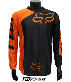 Jersey FOX 180 en color negro con detalles naranja, ideal para motocross y BMX, exhibido en maniquí negro.