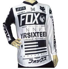 Jersey FOX blanco con diseño gráfico negro YRSIXTEEN, mangas largas y múltiples símbolos, ideal para motocross, BMX o uso urbano.