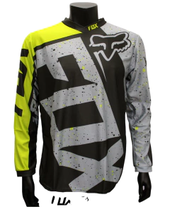 Jersey FOX gris con negro y amarillo, diseño salpicado frontal y logo FOX azul claro sobre el pecho
