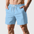 Shorts masculinos azuis claros de tactel liso com bolsos laterais.