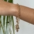 PULSEIRA DE ELOS DUPLA COM PINGENTE MÃO HAMSA E PÉROLA FOLHEADA EM OURO 18K