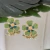 BRINCO DE FLOR ESMALTADA VERDE COM MIOLO DOURADO