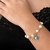 PULSEIRA DE PEROLAS E PINGENTE TREVO E OLHO GREGO FOLHEADO EM OURO 18K