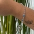 PULSEIRA COM OLHO GREGO E PINGENTE MÃO HAMSA FOLHEADO EM RÓDIO