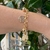PULSEIRA E ELOS COM PINGENTE BOLAS E ORAÇAO DO PAI NOSSO FOLHEADA EM OURO 18
