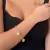 PULSEIRA DE ELOS COM PINGENTE TREVO E MAO HAMSAFOLHEADA EM OURO 18K