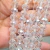 Rondela de cristal transparente de 10mm, com 60 peças em um fio, mostrando o brilho e detalhes facetados das pedras.
