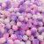 Pérolas craqueladas multicores em diversos tons de rosa e roxo, com textura de bolinhas, disponíveis em um pacote de 100g.