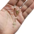 Mini terço com pérolas de 4mm, com cruz dourada e medalha religiosa.