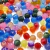 Mix de bolinhas coloridas de 10mm, ideal para artesanato, exibindo diversas cores e texturas.