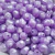 Bolas de resina perolada em tons de roxo, com formato irregular e furo central, ideais para artesanato.